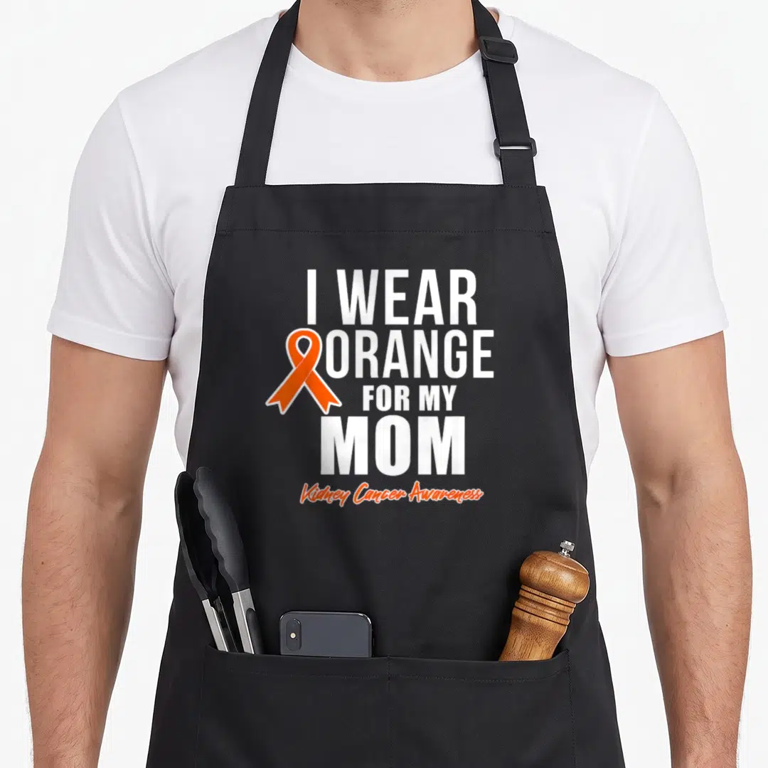 Funny cancer kidney disease awareness apron - I WEAR ORANGE FOR MY MOM text with orange ribbon and Kidney Cancer — shown on a black cotton canvas apron against a white background