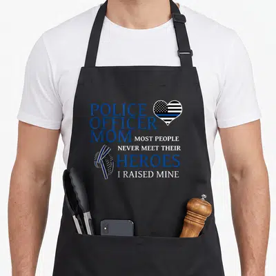 Mama police apron - Blue white black text Police Officer Mom with thin blue line heart and ribbon — shown on a black cotton canvas apron against a white background