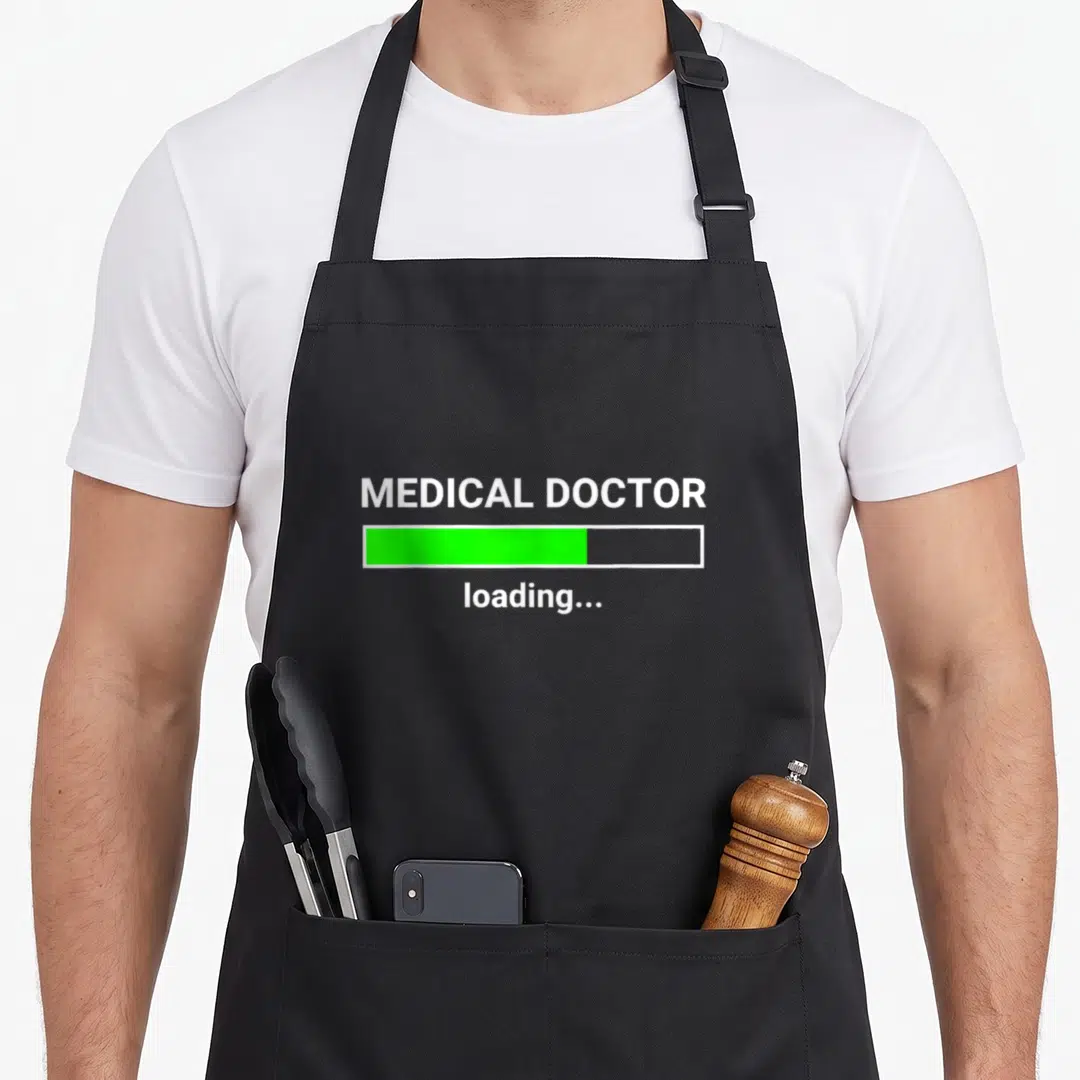 Medical doctor apron - MEDICAL DOCTOR loading text with green progress bar graphic — shown on a black cotton canvas apron against a white background