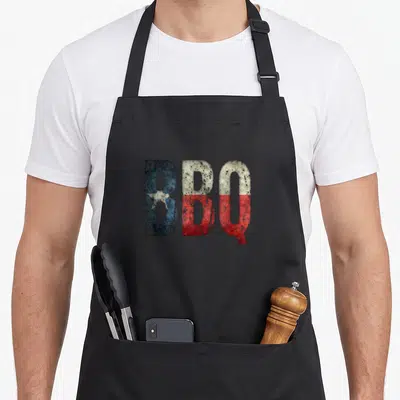 State barbecue apron - Distressed BBQ text in blue white and red Texas flag style — shown on a black cotton canvas apron against a white background