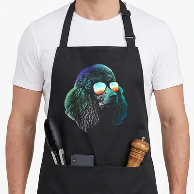 Disco dog apron - Retro poodle head with sunset sunglasses in blue cyan green orange yellow gradient — shown on a black cotton canvas apron against a white background