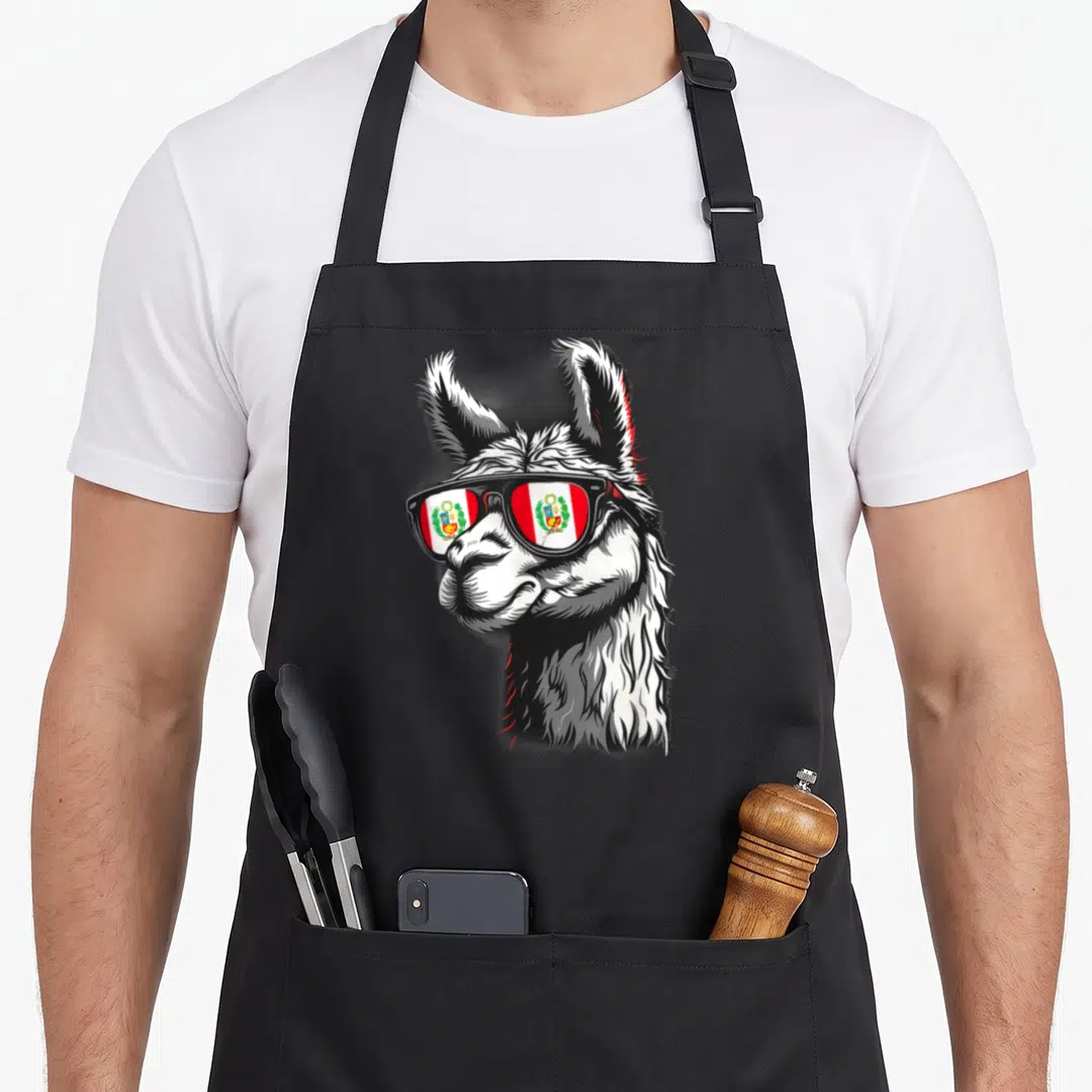 Peru pride apron - Cartoon llama wearing sunglasses with Peruvian flag reflection in white black red — shown on a black cotton canvas apron against a white background