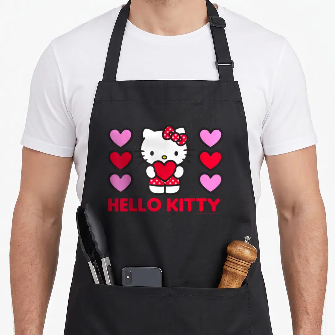Vintage valentine apron - Hello Kitty holding red heart flanked by pink and red heart columns with red text below — shown on a black cotton canvas apron against a white background