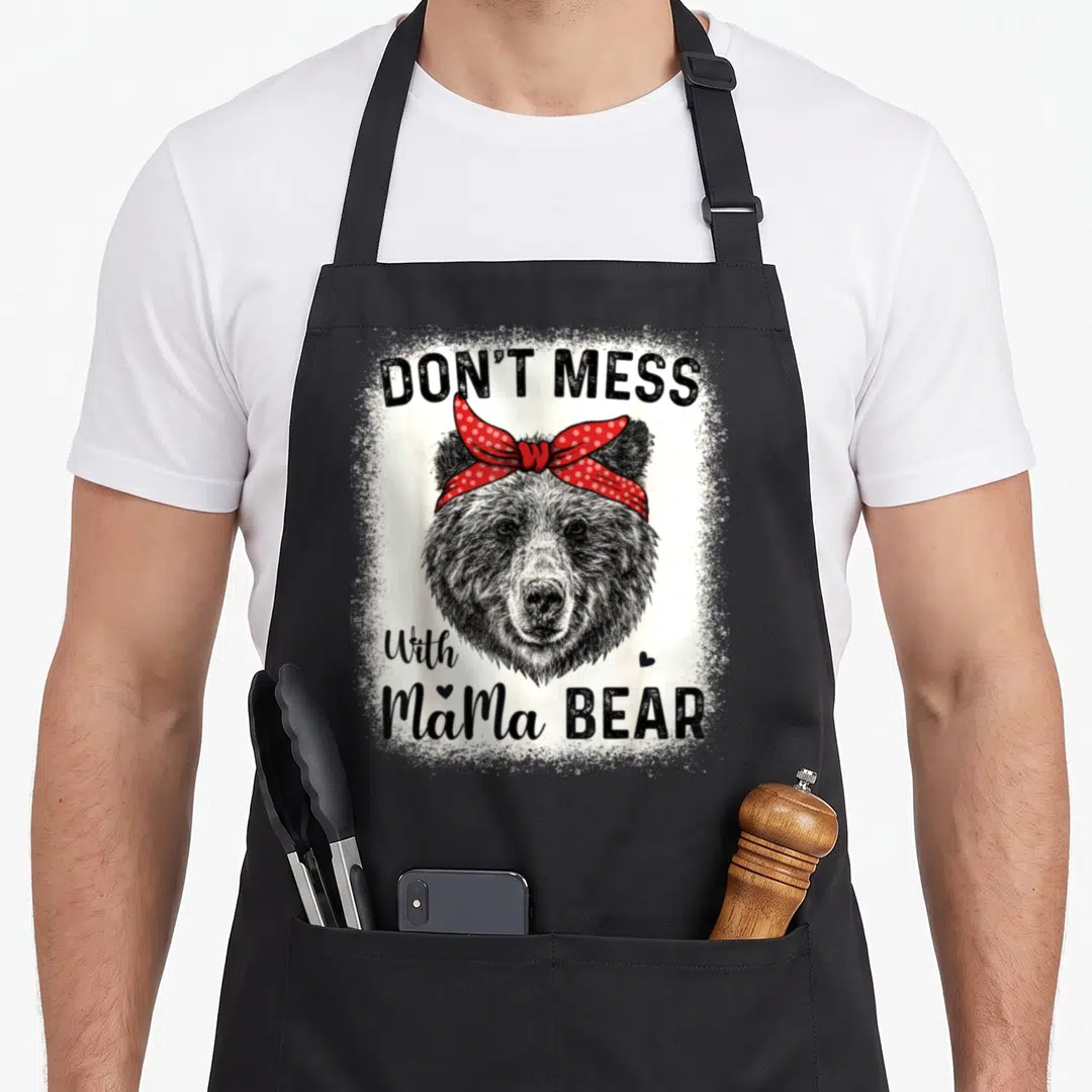 Mess cute bear apron - Realistic bear head with red polka dot bandana and text Don't Mess with Mama Bear — shown on a black cotton canvas apron against a white background