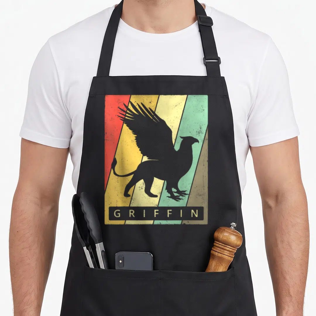 Vintage griffin apron - Grey griffin silhouette over red yellow and green diagonal stripes with text box — shown on a black cotton canvas apron against a white background