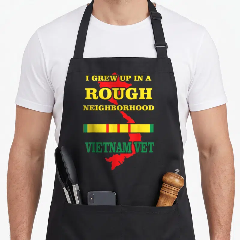 Vietnam honest was apron - I Grew Up In A Rough Neighborhood text over red Vietnam map with multicolored ribbon — shown on a black cotton canvas apron against a white background