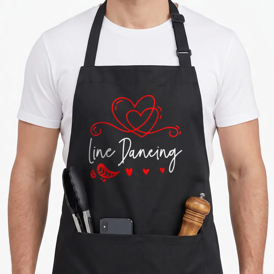 Vintage dancing line apron - Red interlocking hearts above white line Dancing script with paisley and small hearts below — shown on a black cotton canvas apron against a white background