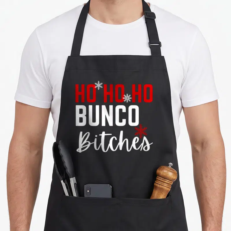 Bunco christmas apron - Red and white stacked text reading Ho Ho Ho Bunco Bitches with three snowflakes — shown on a black cotton canvas apron against a white background