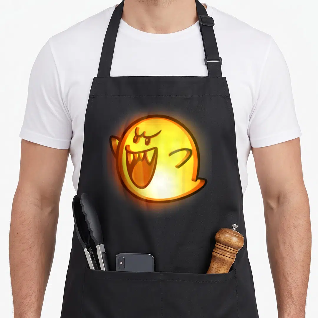 Boo halloween kitchen aprons - Cartoon ghost with angry face in yellow and orange — shown on a black cotton canvas apron against a white background