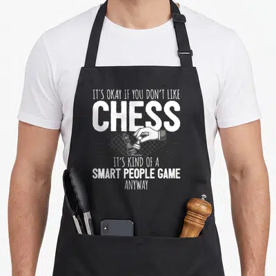Vintage chess player apron - White text reading smart people game above a hand moving a pawn on a diamond chessboard — shown on a black cotton canvas apron against a white background