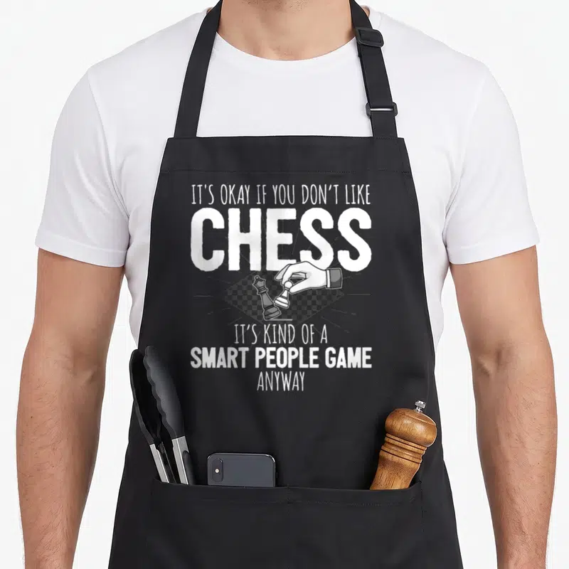 Vintage chess player apron - White text reading smart people game above a hand moving a pawn on a diamond chessboard — shown on a black cotton canvas apron against a white background