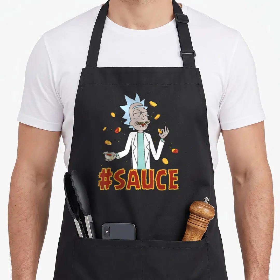 Cute sauce apron - Cartoon scientist in white coat holding sauce cup surrounded by floating nuggets and red hashtag text — shown on a black cotton canvas apron against a white background