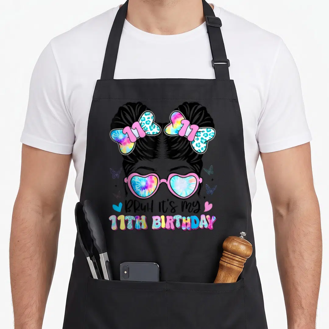 Bruh 11th birthday apron - Girl with space buns and tie-dye glasses wearing 11th birthday apron — shown on a black cotton canvas apron against a white background