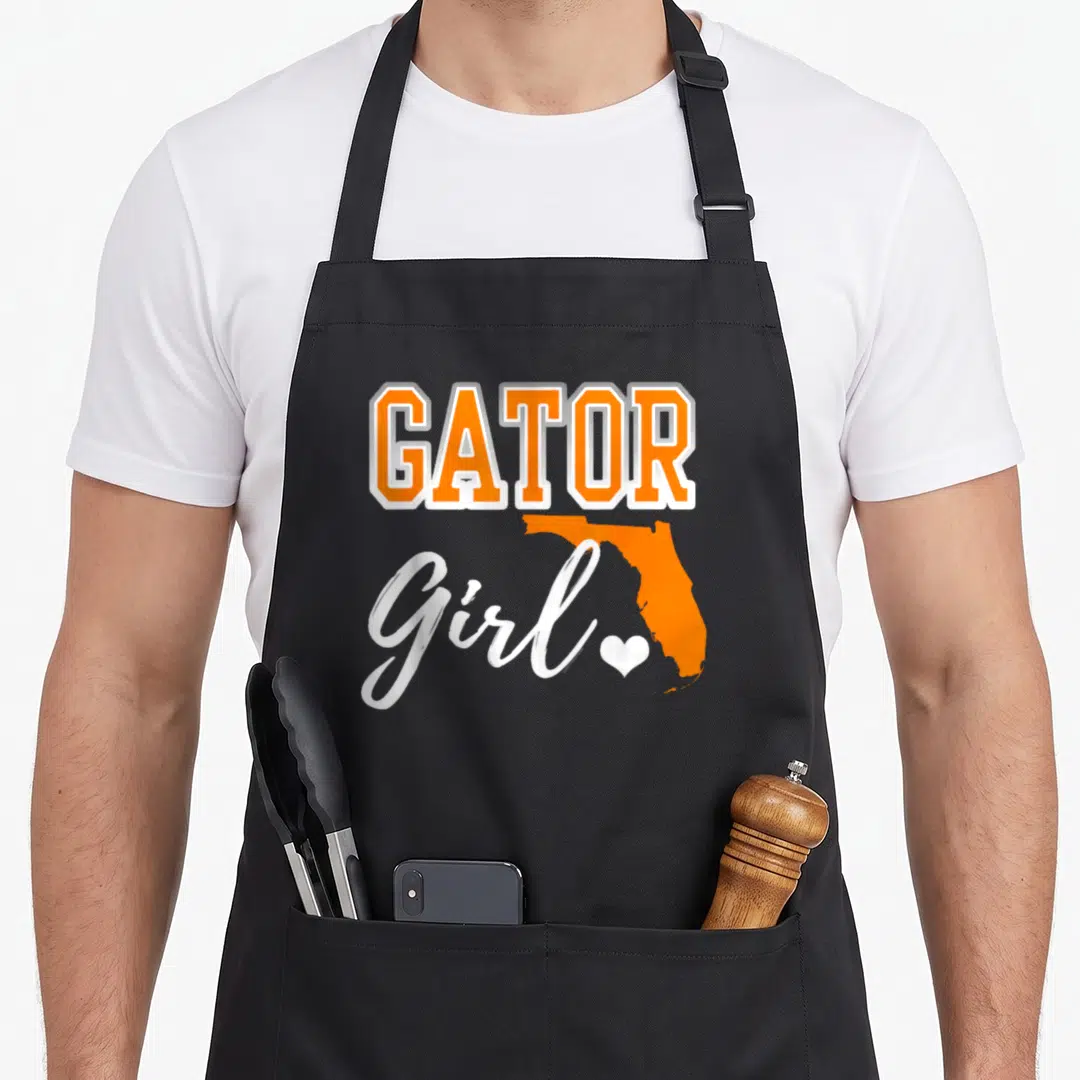 Map florida apron - GATOR Girl text with orange Florida map and white heart on black apron — shown on a black cotton canvas apron against a white background
