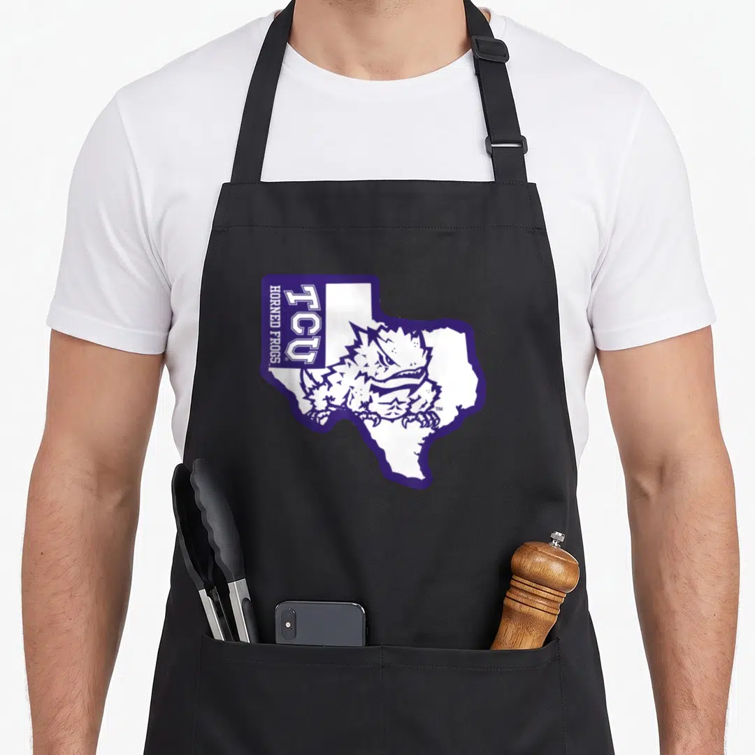 State frog aprons - Purple Texas outline containing cartoon horned frog with vertical TCU HORNED FROGS text — shown on a black cotton canvas apron against a white background