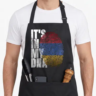 Sign pride apron - IT'S IN MY DNA text beside red blue orange striped fingerprint — shown on a black cotton canvas apron against a white background