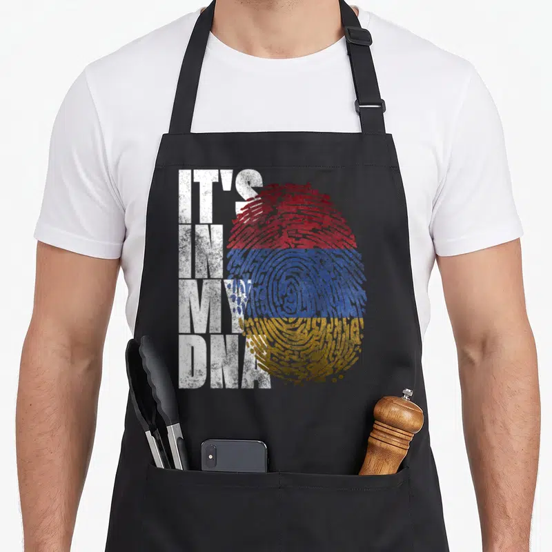 Sign pride apron - IT'S IN MY DNA text beside red blue orange striped fingerprint — shown on a black cotton canvas apron against a white background