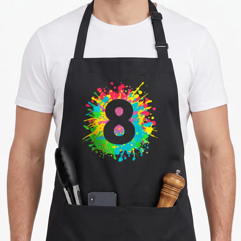 8th paint apron - Grey number 8 over pink, yellow, blue, green, and red paint splatters — shown on a black cotton canvas apron against a white background