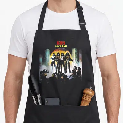 Kiss gun apron - KISS LOVE GUN text above four band members and crowd silhouette — shown on a black cotton canvas apron against a white background