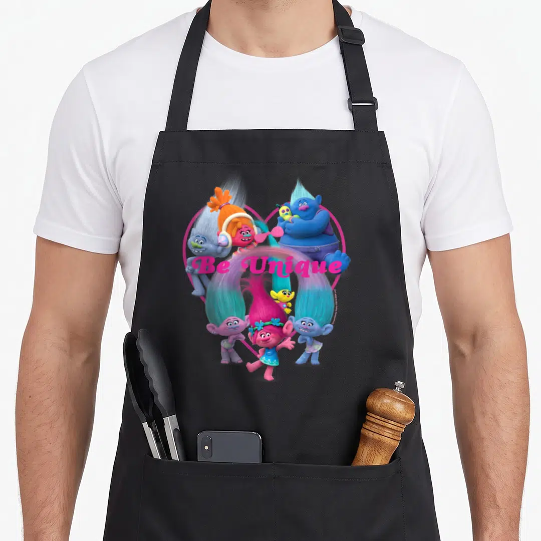 Troll unique apron - Be Unique text over cartoon trolls inside a pink heart outline — shown on a black cotton canvas apron against a white background