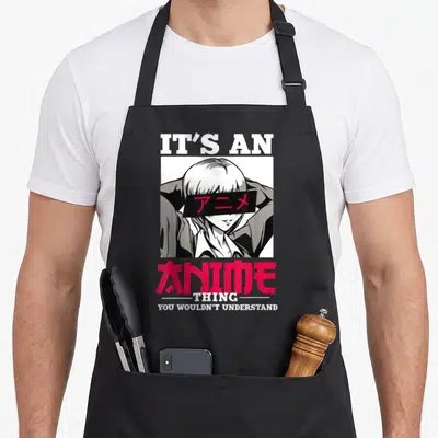 Manga cosplay anime apron - Anime character with censored eyes and It's an Anime Thing text in white and red — shown on a black cotton canvas apron against a white background