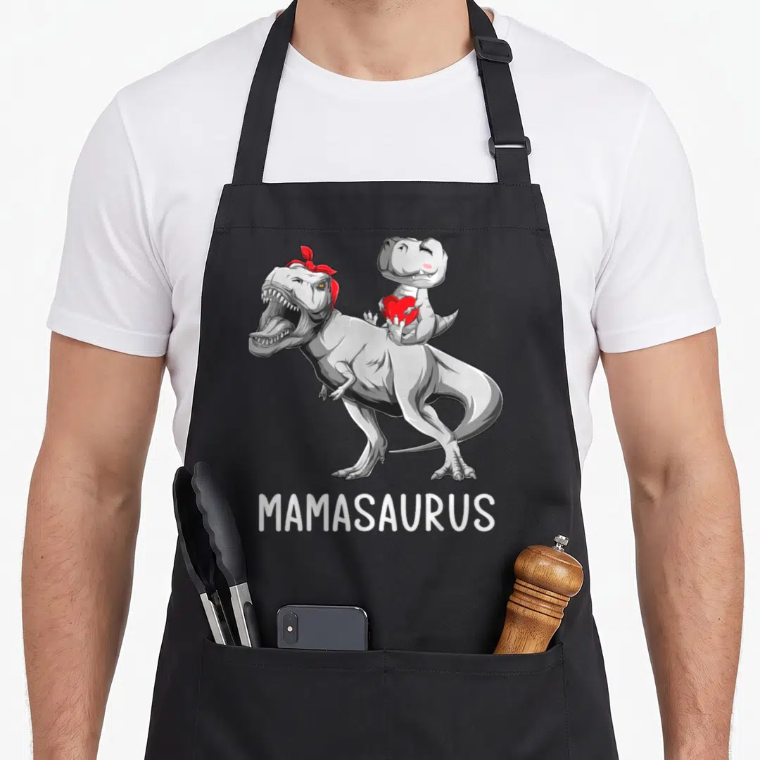 Dinosaur mother's day aprons - Grey dinosaur with red bandana and baby holding red heart above MAMASAURUS text — shown on a black cotton canvas apron against a white background
