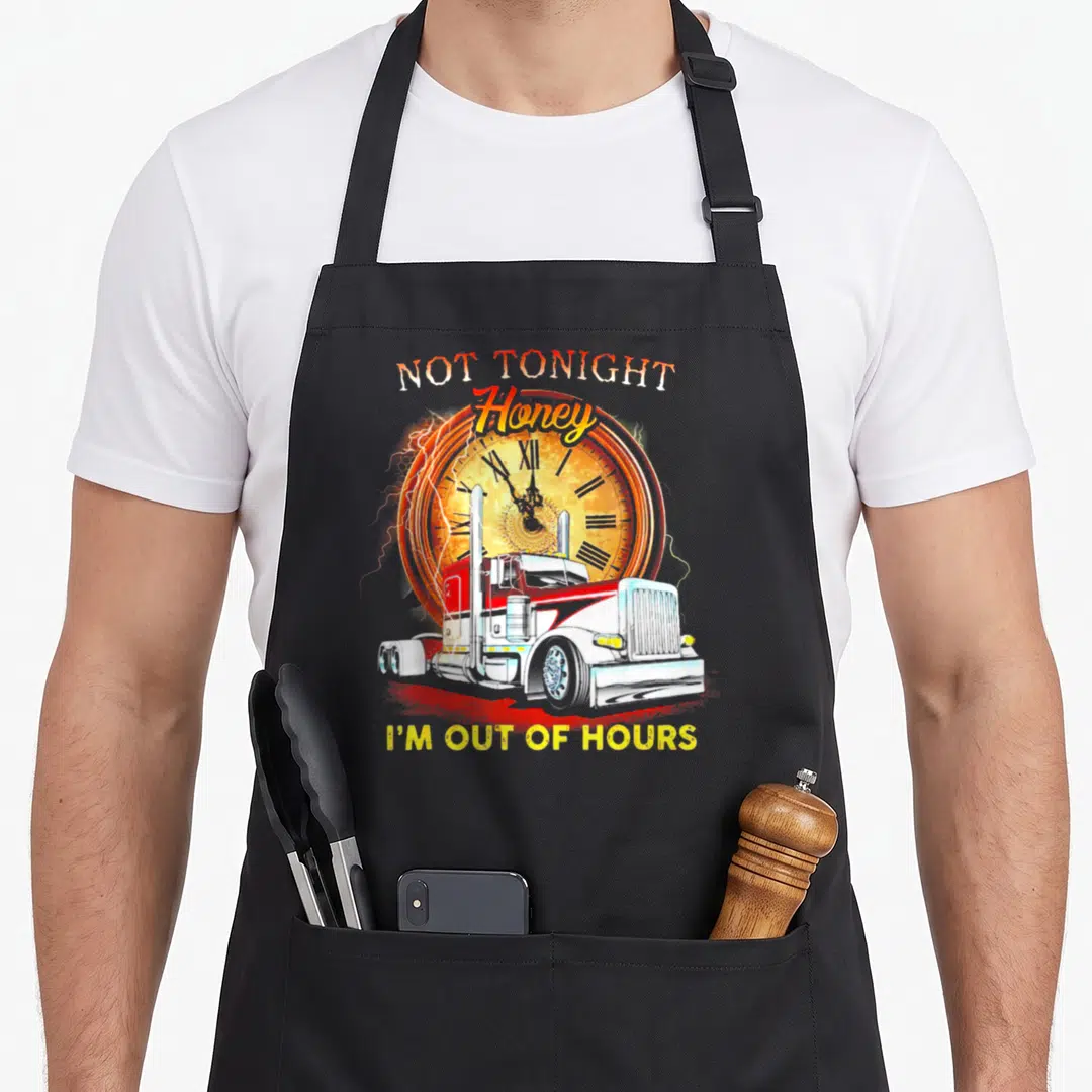 Tonight rigs apron - Red semi-truck in front of orange clock with lightning bolts and yellow text reading I'M OUT — shown on a black cotton canvas apron against a white background