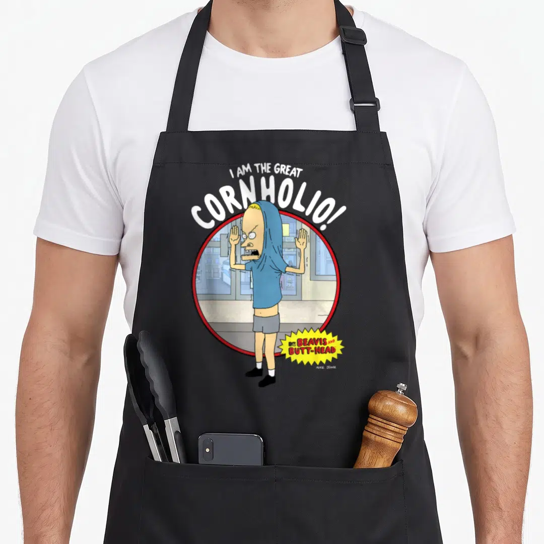 Butt beaverton apron - I AM THE GREAT CORNHOLIO text over character in red circle with yellow burst logo — shown on a black cotton canvas apron against a white background