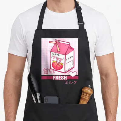 90s strawberry apron - Pink milk carton with straw, strawberries, Japanese text, and FRESH banner on grid background — shown on a black cotton canvas apron against a white background