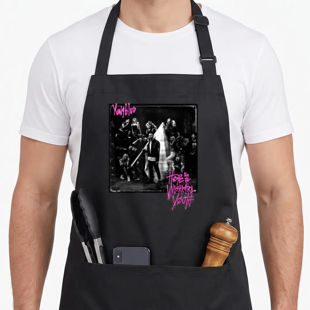 Yungblud youth apron - Pink graffiti text YUNGBLUD and Hope for the Underrated Youth above black and white crowd photo — shown on a black cotton canvas apron against a white background