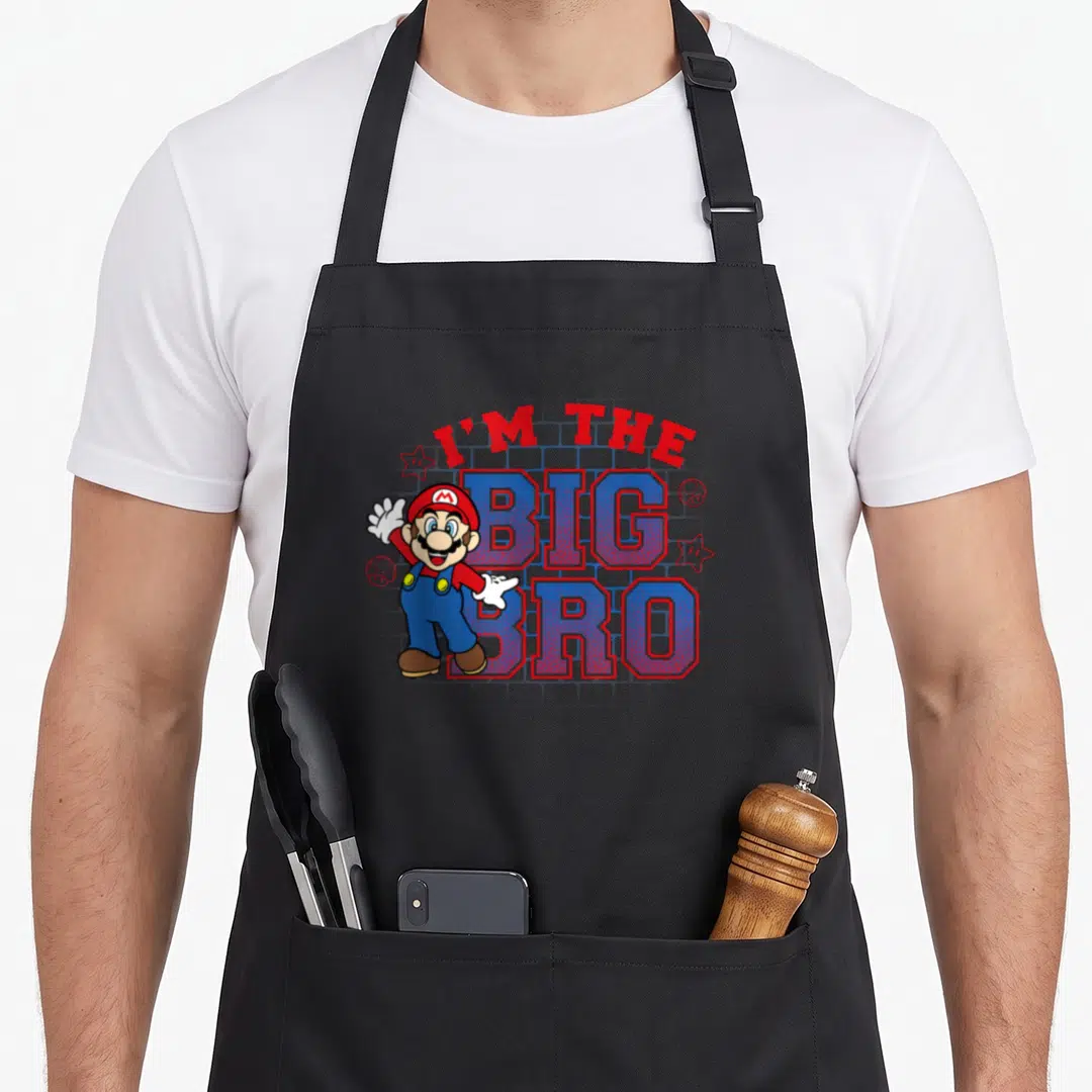 Portrait big brother apron - Mario character next to I'M THE BIG BRO text with stars and mushrooms — shown on a black cotton canvas apron against a white background