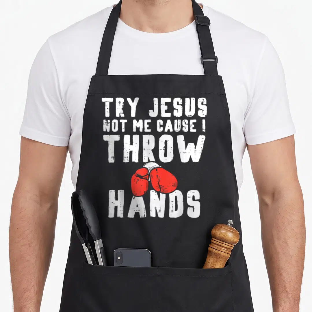 Try christian apron - Red boxing gloves between white text reading TRY JESUS NOT ME CAUSE I THROW HANDS — shown on a black cotton canvas apron against a white background