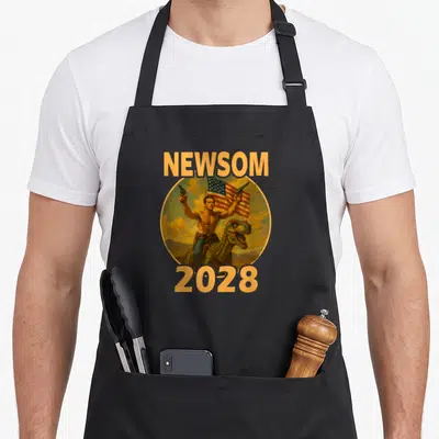 Gavin patriotic apron - Newsom 2028 text above and below a man riding a dinosaur holding two guns inside a circular — shown on a black cotton canvas apron against a white background