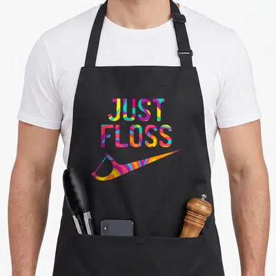 Dental dentist apron - Stacked Just Floss text and floss pick in yellow cyan magenta orange — shown on a black cotton canvas apron against a white background