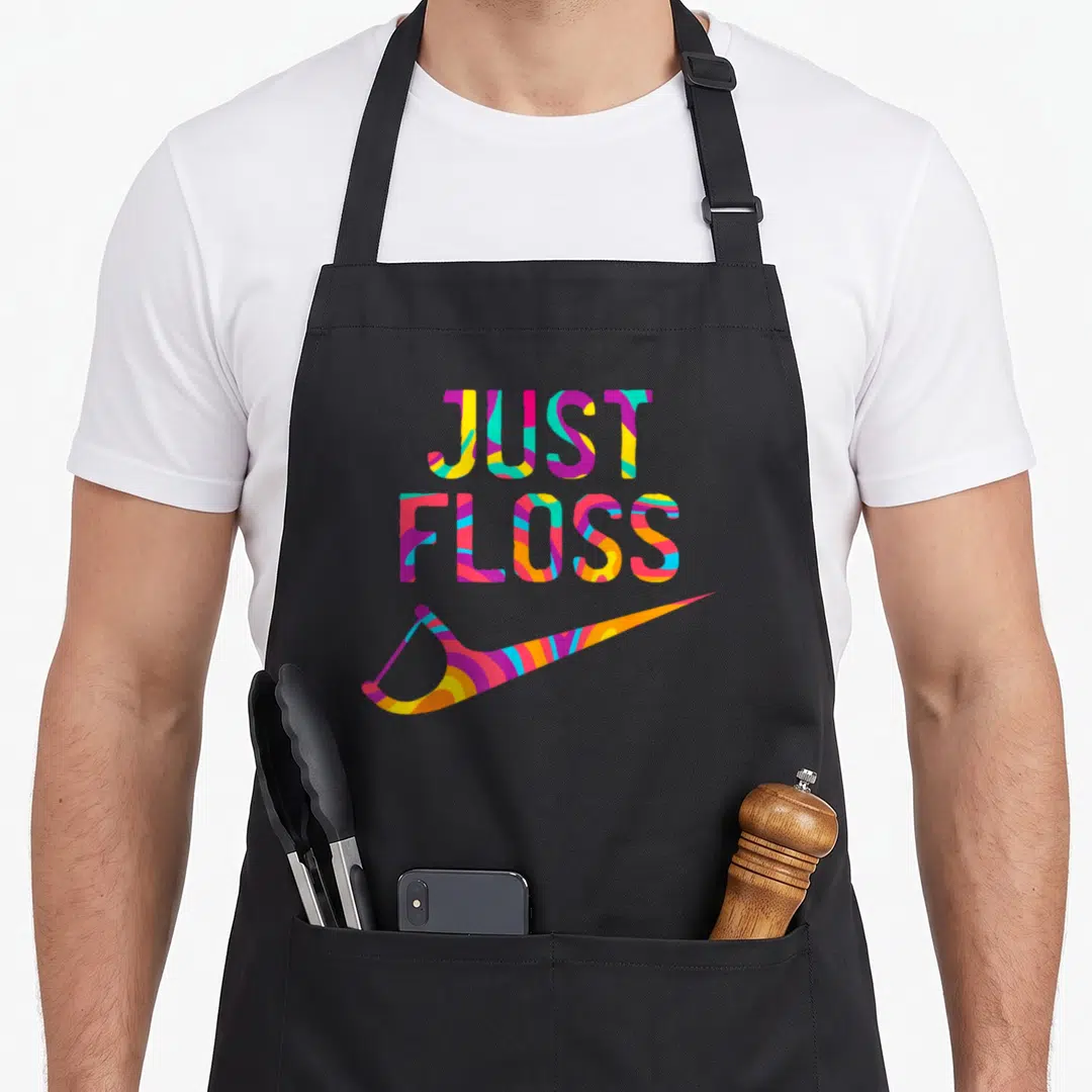 Dental dentist apron - Stacked Just Floss text and floss pick in yellow cyan magenta orange — shown on a black cotton canvas apron against a white background
