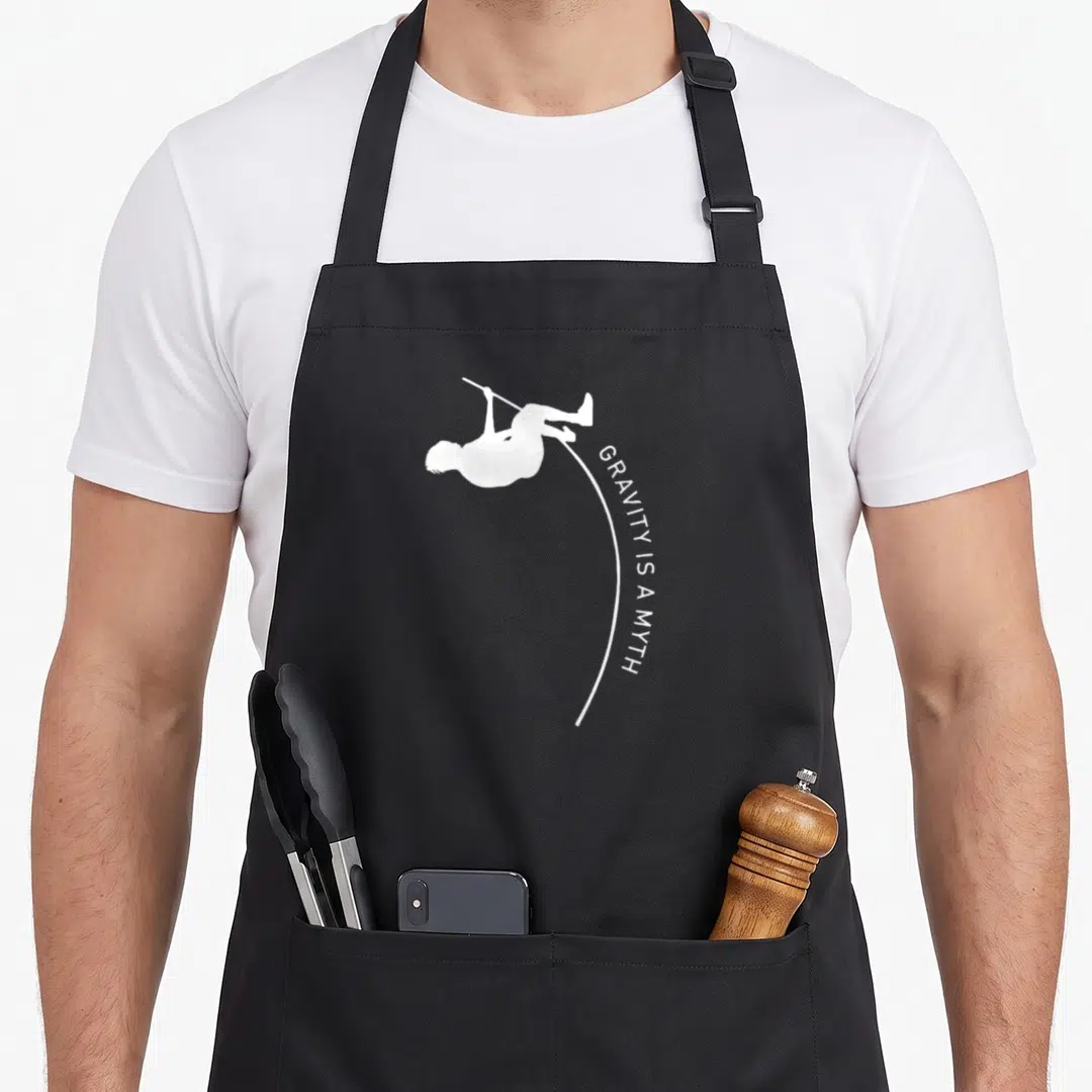 Vault track apron - White silhouette of person on pole with curved text GRAVITY IS A MYTH — shown on a black cotton canvas apron against a white background