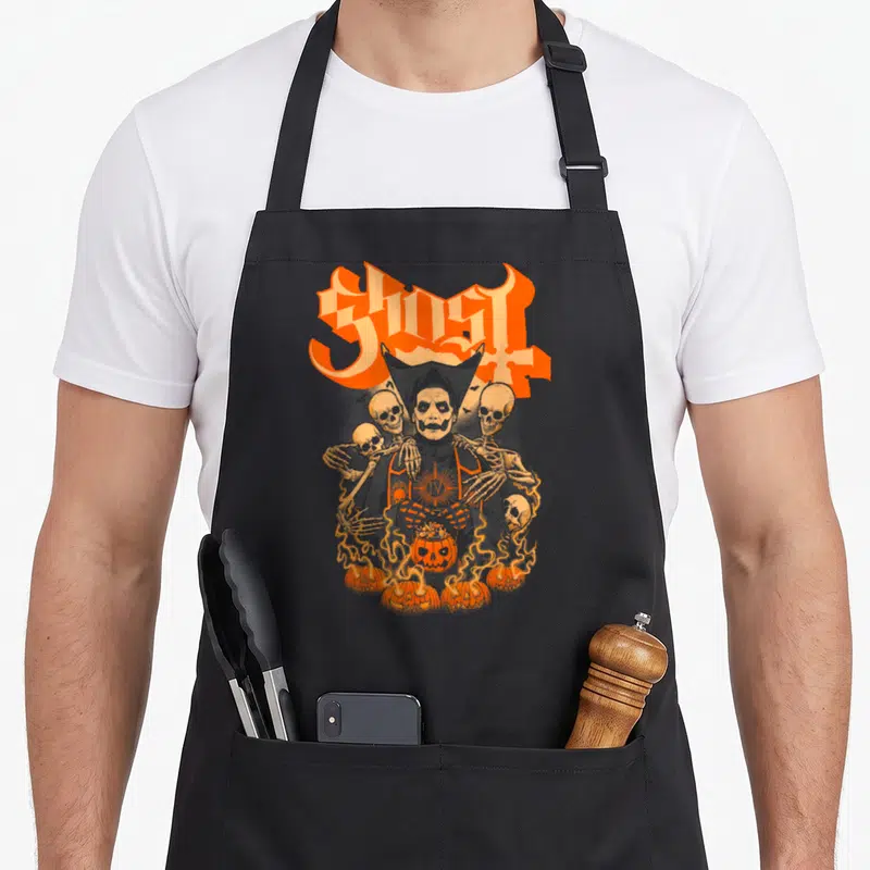 Funny ghost halloween apron - GHOST text above Papa Emeritus with skulls and flaming pumpkins in orange and grey — shown on a black cotton canvas apron against a white background