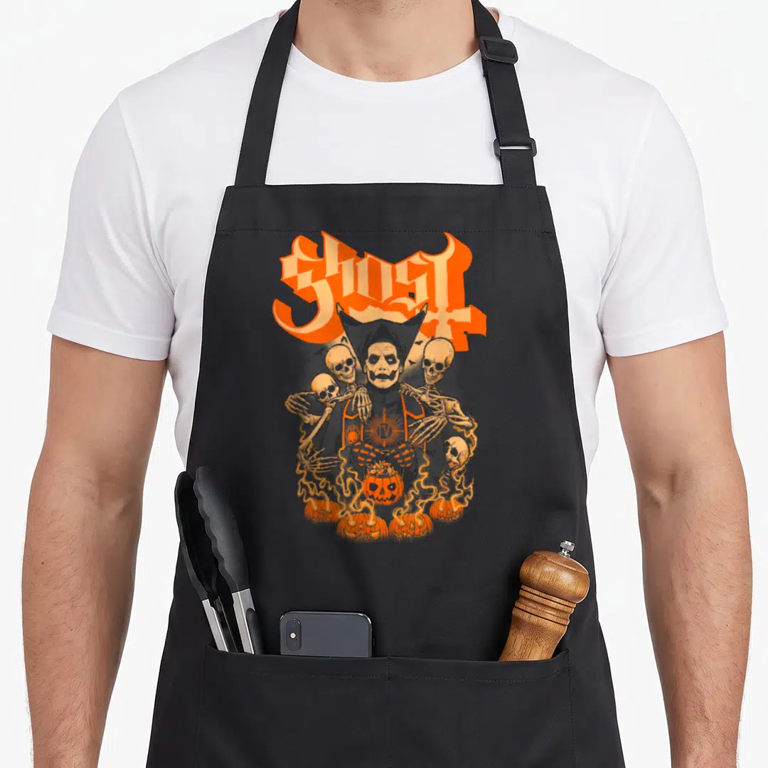 Funny ghost halloween apron - GHOST text above Papa Emeritus with skulls and flaming pumpkins in orange and grey — shown on a black cotton canvas apron against a white background