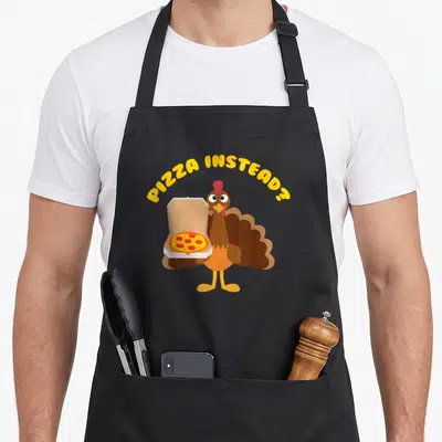 Pizza turkey apron - Cartoon turkey holding pizza box under PIZZA INSTEAD? text — shown on a black cotton canvas apron against a white background