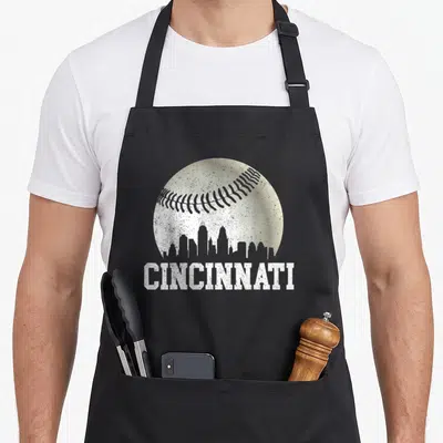 Distressed baseball apron - White distressed Cincinnati text under a baseball containing a city skyline silhouette — shown on a black cotton canvas apron against a white background