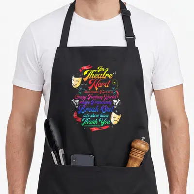 Thespian theatre apron - Stacked colorful text reading I'm a Theatre Nerd surrounded by masks spotlights and red — shown on a black cotton canvas apron against a white background