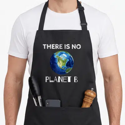Planet ecologist apron - THERE IS NO PLANET B text framing a blue and green Earth globe — shown on a black cotton canvas apron against a white background