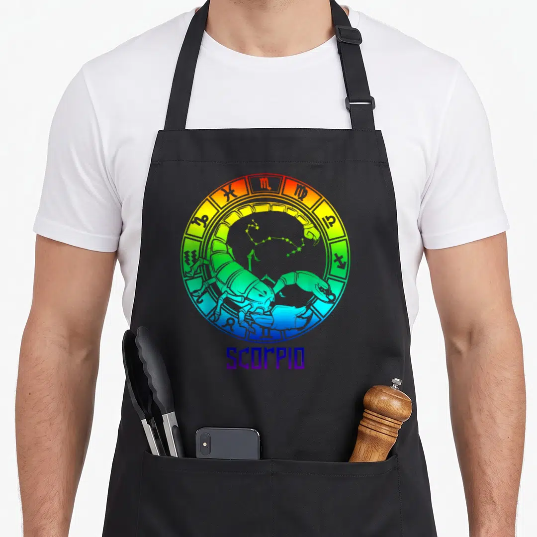 Sign star birthday apron - Rainbow gradient zodiac wheel with cartoon scorpion, constellation, and SCORPIO text below — shown on a black cotton canvas apron against a white background