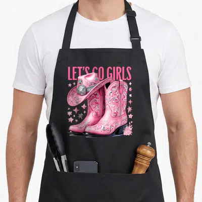 Coquette country apron - Pink cowgirl boots with cowboy hat, stars, flower, and LET'S GO GIRLS text — shown on a black cotton canvas apron against a white background