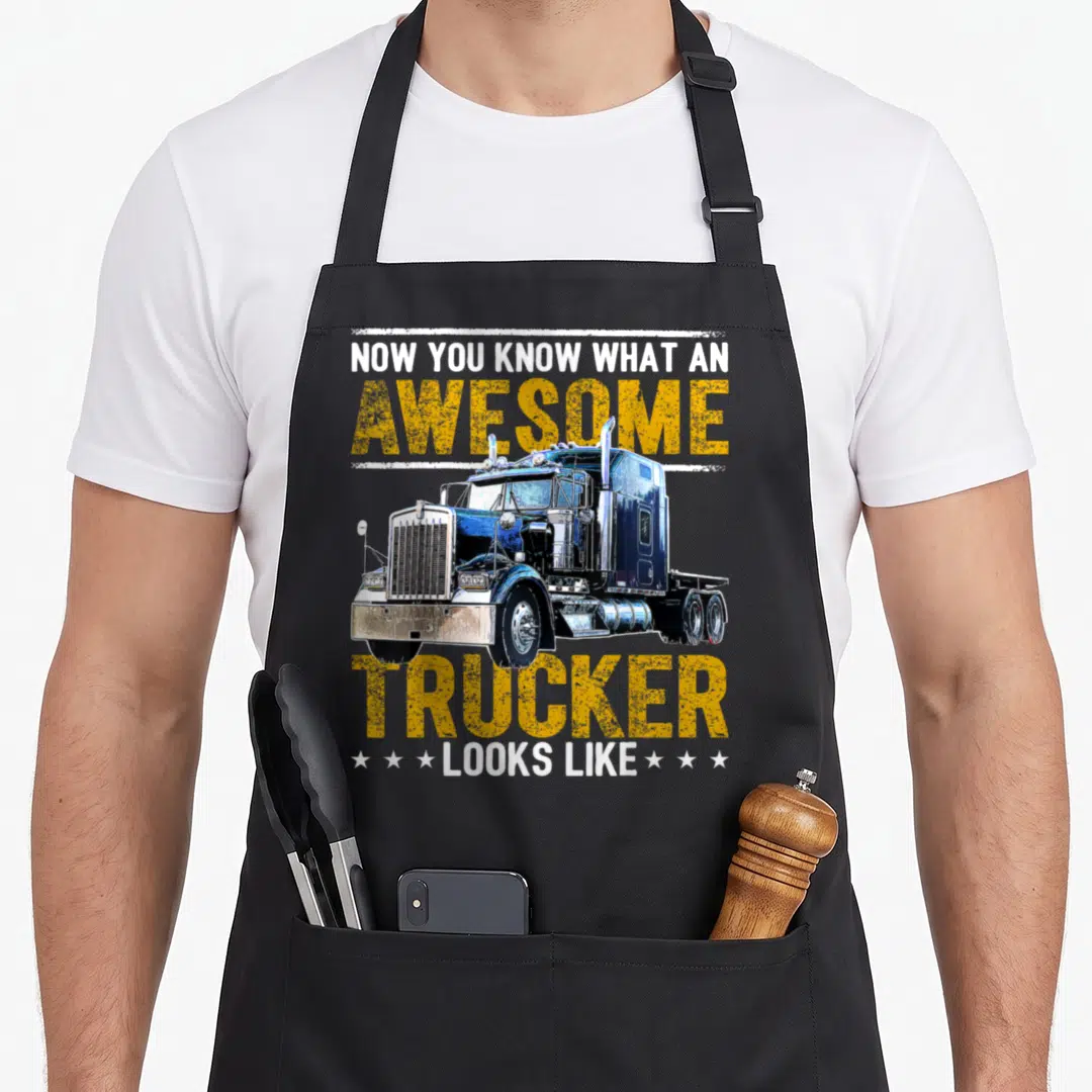 Rig semi truck apron - Blue semi-truck illustration with white and yellow distressed text on black fabric — shown on a black cotton canvas apron against a white background