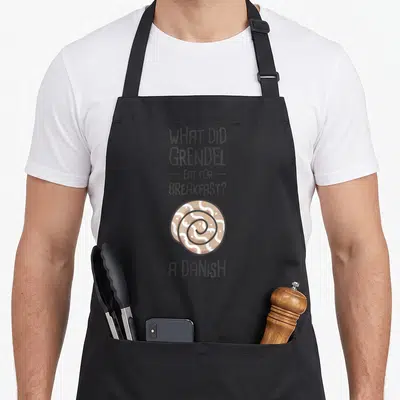 Literature english apron - Grey text asking about Grendel's breakfast above a tan and white spiral pastry — shown on a black cotton canvas apron against a white background