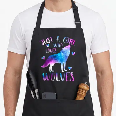 Watercolor wolf wolves apron - Watercolor wolf in blue and purple with text JUST A GIRL WHO LOVES WOLVES and four hearts — shown on a black cotton canvas apron against a white background