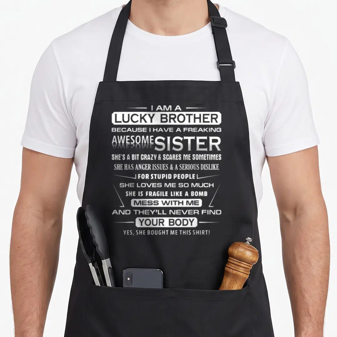 Brother christmas apron - White stacked typography reading I Am A Lucky Brother Because I Have A Freaking Awesome Sister — shown on a black cotton canvas apron against a white background