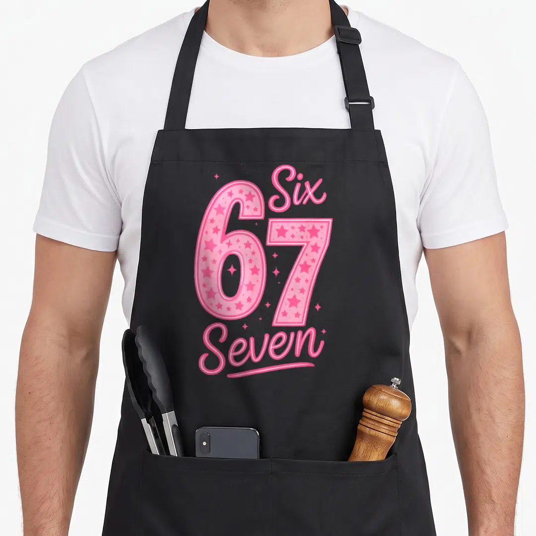 Number six meme apron - Pink 6 and 7 digits with stars and cursive Six Seven text labels — shown on a black cotton canvas apron against a white background