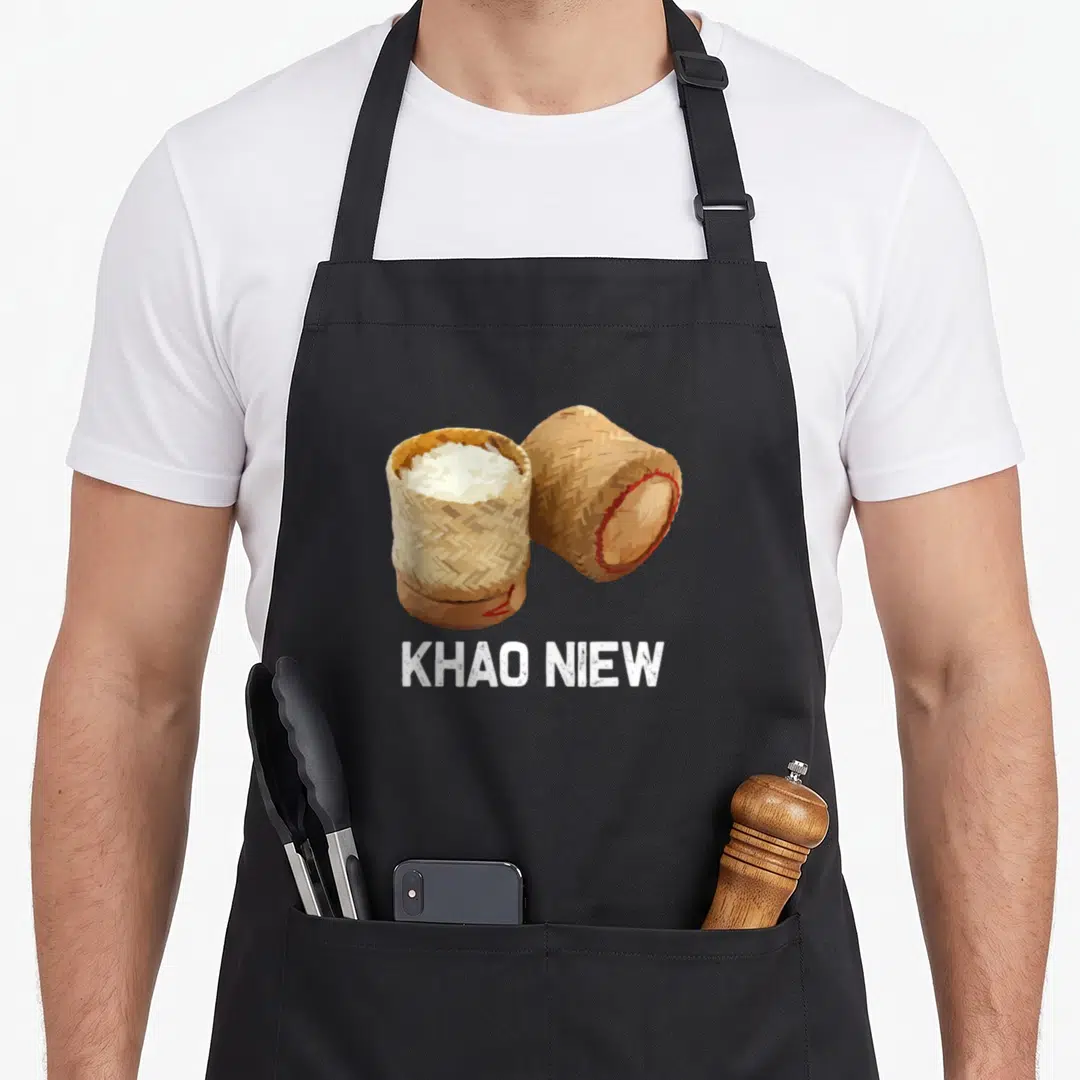 Sticky thai food apron - Two tan woven bamboo baskets with white rice and KHAO NIEW text below — shown on a black cotton canvas apron against a white background